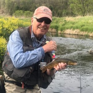 A fly fisher, Steve Engelbert, about to release a medium small trout in the driftless area of southwest Wisconsin, Photo by Ed Culhane.